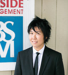 Photo of Carmin Wong in front of Bayside Management sign
