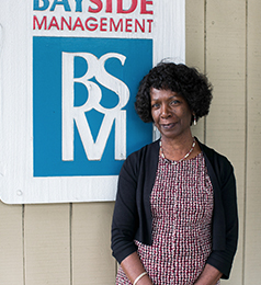 Photo of Pauline Smith in front of Bayside Management sign
