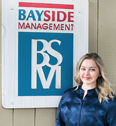 Photo of Victoria Taylor in front of Bayside Management sign