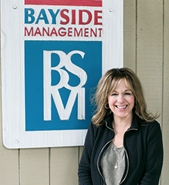 Photo of Yvette Perreca in front of Bayside Management sign.